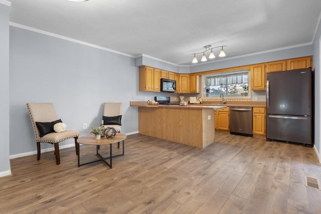 kitchen with crown molding, light hardwood / wood-style flooring, kitchen peninsula, and black appliances