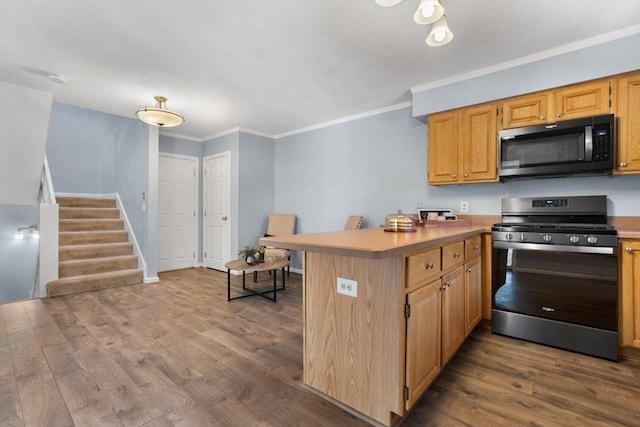 kitchen with a breakfast bar area, crown molding, wood-type flooring, stainless steel range, and kitchen peninsula