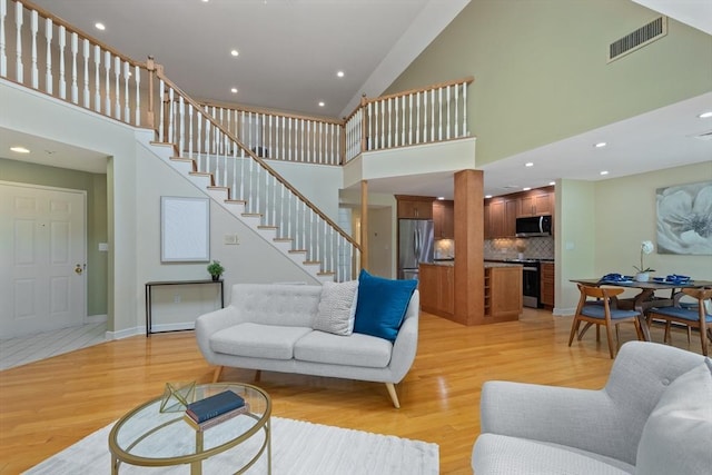 501 Lexington St Unit 35, Waltham, MA 02452 - living area with a towering ceiling, light wood finished floors, stairway, recessed lighting, and baseboards