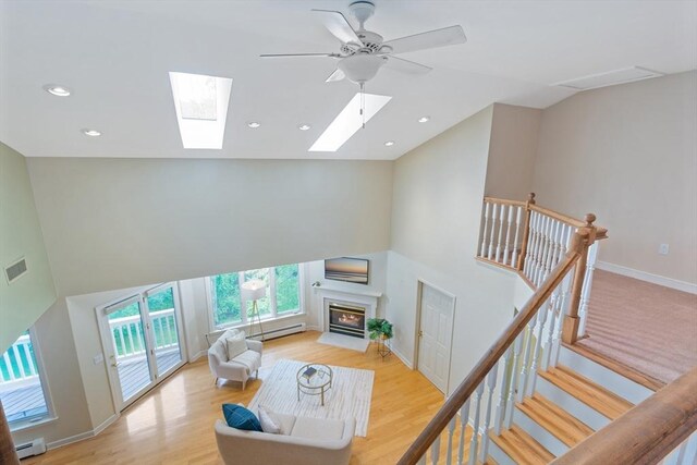 501 Lexington St Unit 35, Waltham, MA 02452 - living area featuring a baseboard radiator, high vaulted ceiling, a fireplace with flush hearth, light wood-style flooring, and recessed lighting