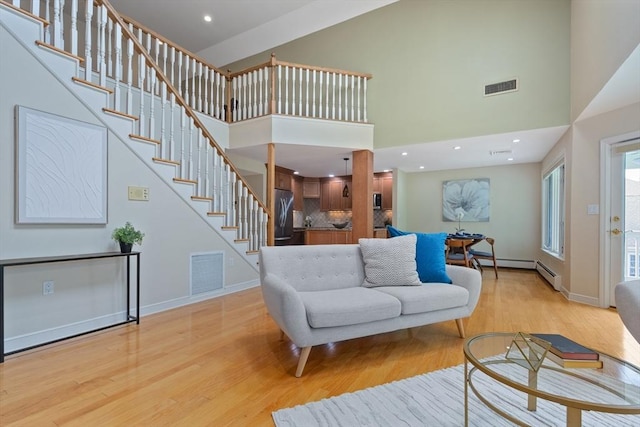 501 Lexington St Unit 35, Waltham, MA 02452 - living area featuring light wood-type flooring, a towering ceiling, stairway, baseboards, and recessed lighting
