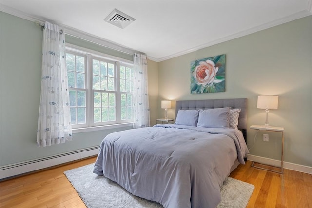 501 Lexington St Unit 35, Waltham, MA 02452 - bedroom featuring ornamental molding, wood finished floors, baseboard heating, and baseboards