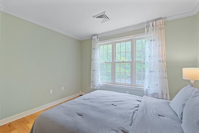501 Lexington St Unit 35, Waltham, MA 02452 - bedroom with ornamental molding, baseboards, wood finished floors, and baseboard heating