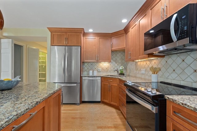 501 Lexington St Unit 35, Waltham, MA 02452 - kitchen with appliances with stainless steel finishes, a sink, brown cabinetry, decorative backsplash, and recessed lighting