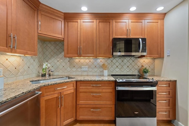 501 Lexington St Unit 35, Waltham, MA 02452 - kitchen featuring appliances with stainless steel finishes, a sink, light stone counters, and tasteful backsplash