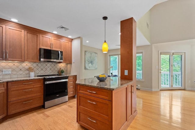 501 Lexington St Unit 35, Waltham, MA 02452 - kitchen with stainless steel appliances, light wood-style floors, tasteful backsplash, light stone counters, and recessed lighting