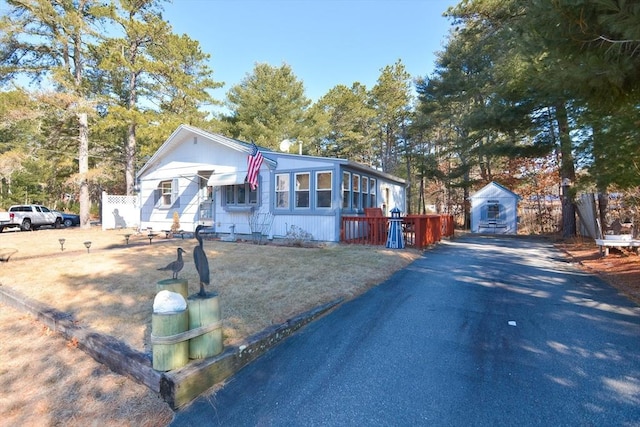 view of front of house with driveway and a storage shed