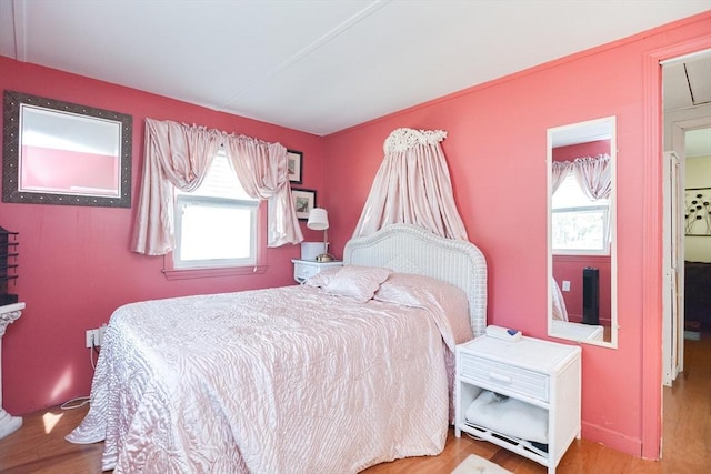 bedroom featuring multiple windows and wood finished floors