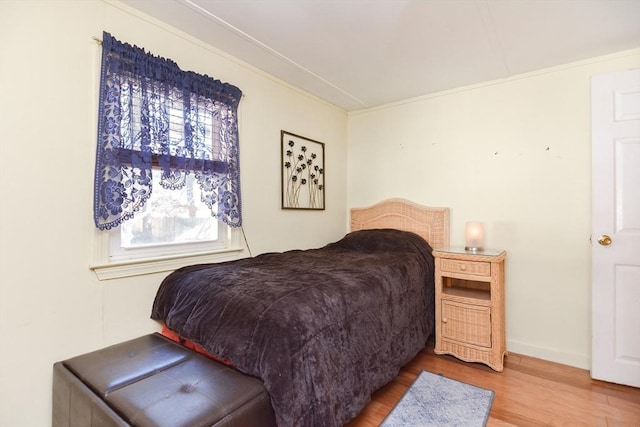 bedroom featuring crown molding and wood finished floors