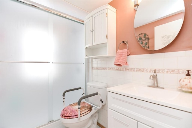 full bathroom with toilet, a shower with shower door, a wainscoted wall, vanity, and tile walls