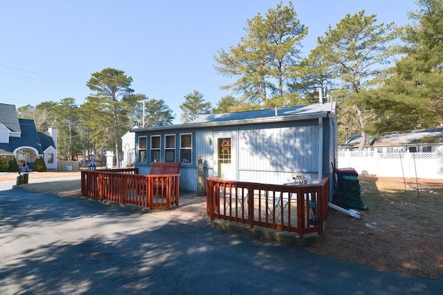 view of front of home featuring fence and a wooden deck