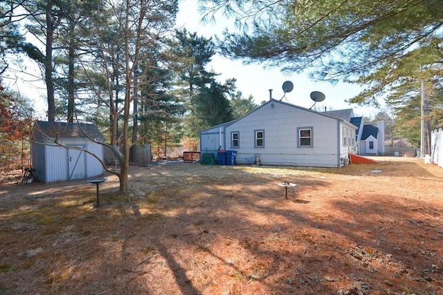 rear view of house with a shed, an outdoor structure, and fence