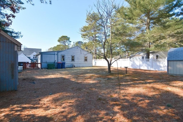 view of yard featuring a fenced backyard and a storage unit