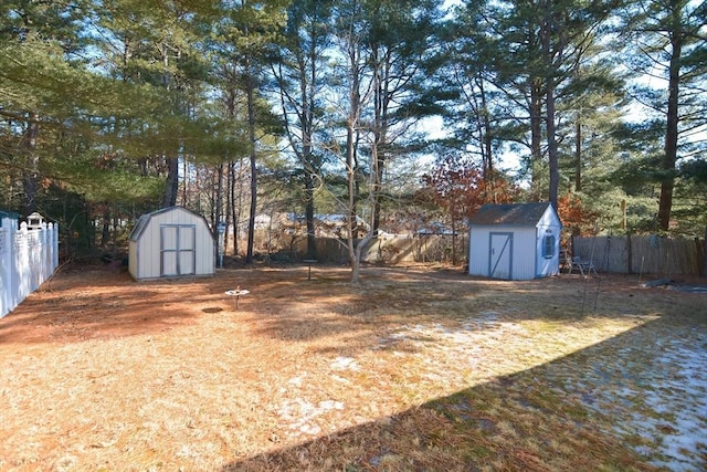 view of yard featuring a storage unit, an outdoor structure, and a fenced backyard