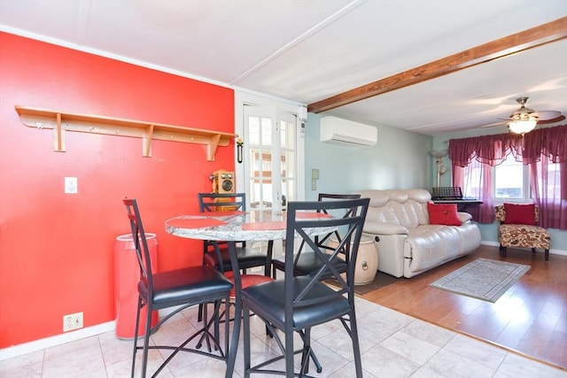 dining room featuring an AC wall unit, ceiling fan, wood finished floors, beamed ceiling, and baseboards