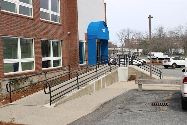 view of exterior entry featuring uncovered parking and brick siding