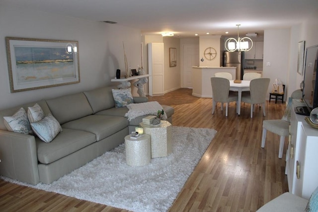 living room featuring a notable chandelier and wood finished floors