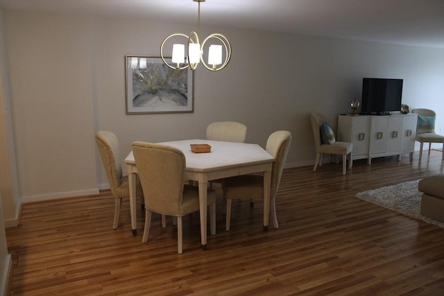 dining room with an inviting chandelier, baseboards, and wood finished floors