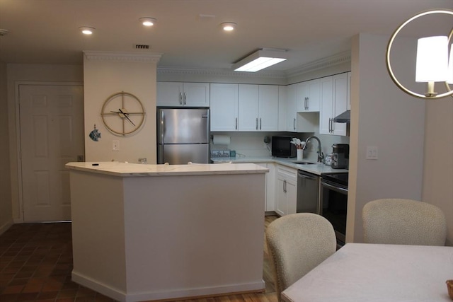 kitchen with a center island, light countertops, under cabinet range hood, a sink, and appliances with stainless steel finishes