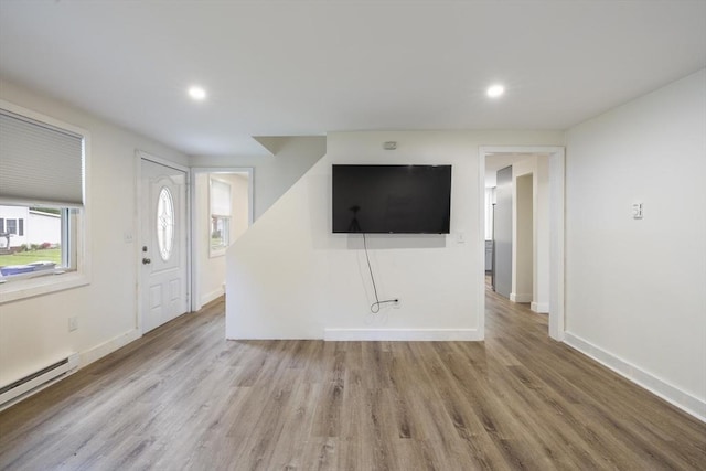 53 Kalish Ave, Enfield, CT 06082 - unfurnished living room featuring a baseboard heating unit, wood finished floors, baseboards, and recessed lighting