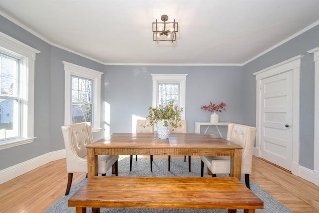 dining space with plenty of natural light, ornamental molding, and light hardwood / wood-style flooring