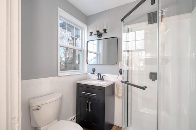 bathroom with vanity, an enclosed shower, a healthy amount of sunlight, and tile walls