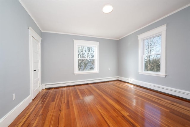 spare room featuring ornamental molding, wood-type flooring, and a baseboard heating unit