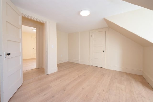 bonus room with light hardwood / wood-style floors and vaulted ceiling