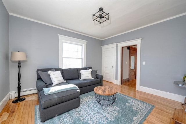 living room featuring baseboard heating, crown molding, and hardwood / wood-style flooring