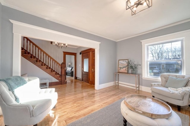 living room with hardwood / wood-style flooring, a notable chandelier, and crown molding