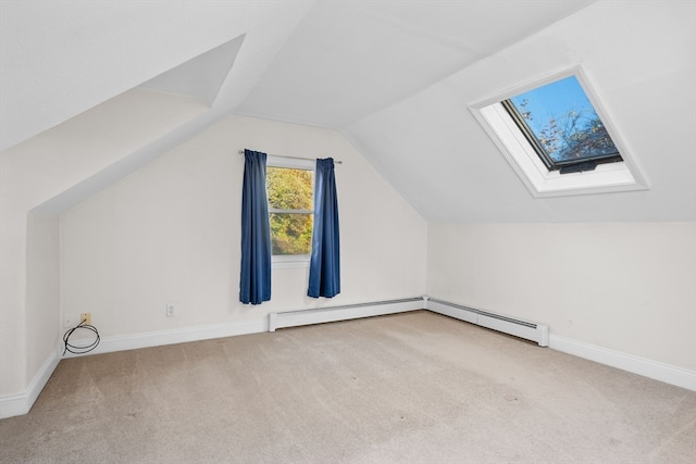 bonus room with vaulted ceiling with skylight, light colored carpet, and a baseboard radiator