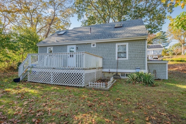 rear view of property featuring a deck and a lawn