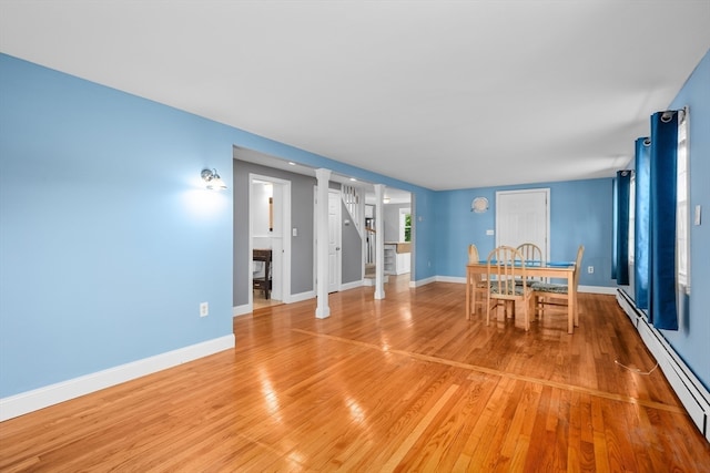 unfurnished dining area with wood-type flooring and baseboard heating