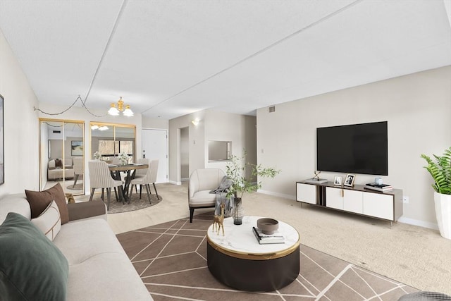 carpeted living room with an inviting chandelier