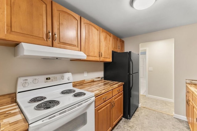 127 King St Unit 104, Franklin, MA 02038 - kitchen with white electric range, under cabinet range hood, freestanding refrigerator, butcher block counters, and baseboards
