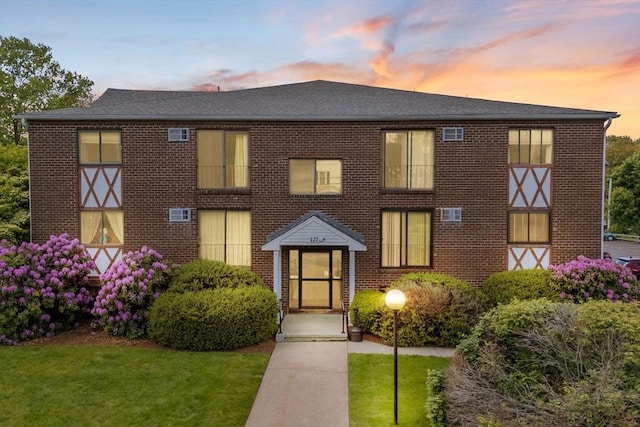 127 King St Unit 104, Franklin, MA 02038 - view of front facade featuring brick siding, a front lawn, and a shingled roof