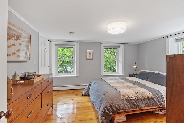 18 River St Unit 18, Andover, MA 01810 - bedroom with a baseboard heating unit, light wood finished floors, and crown molding