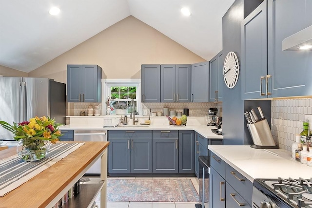 18 River St Unit 18, Andover, MA 01810 - kitchen with light countertops, appliances with stainless steel finishes, tasteful backsplash, high vaulted ceiling, and light tile patterned flooring