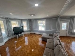 living room featuring crown molding and parquet flooring