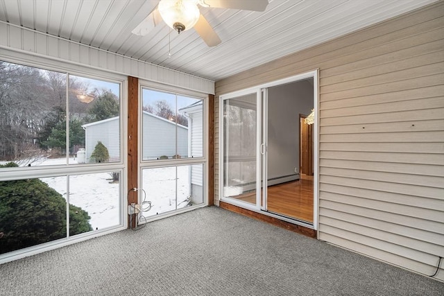 unfurnished sunroom featuring baseboard heating, ceiling fan, and a wealth of natural light