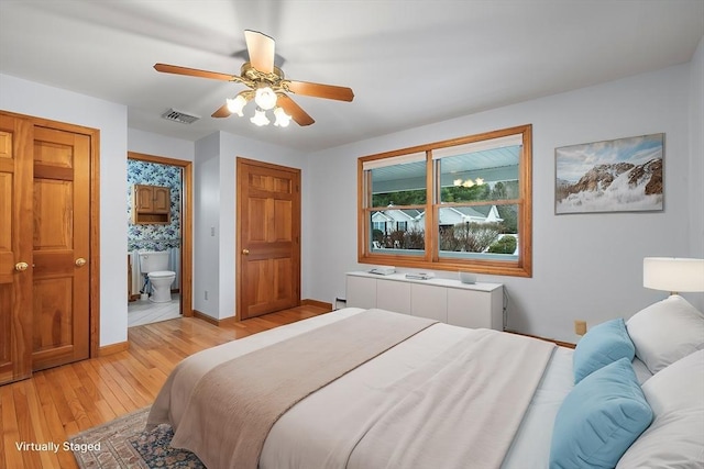 bedroom with ceiling fan, radiator heating unit, light wood-type flooring, and ensuite bath