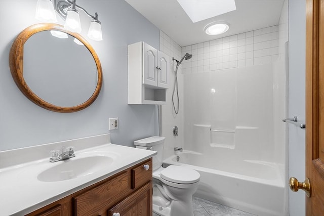 full bathroom featuring a skylight, vanity, tiled shower / bath, tile patterned floors, and toilet