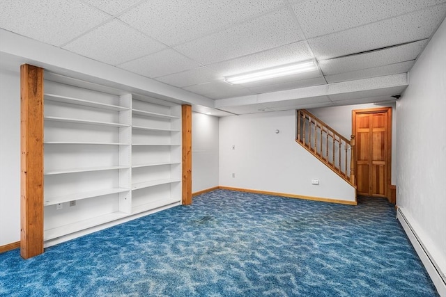 basement featuring a baseboard radiator, a drop ceiling, and dark carpet