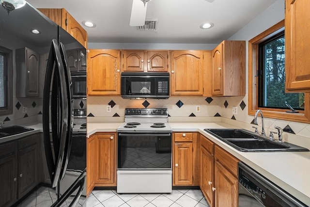 kitchen with sink, light tile patterned floors, black appliances, and backsplash