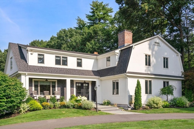 19 Buckmaster Dr, Sudbury, MA 01776 - view of front of house featuring a shingled roof, a front yard, covered porch, and a chimney