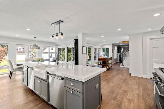 19 Buckmaster Dr, Sudbury, MA 01776 - kitchen with a healthy amount of sunlight, a center island with sink, gray cabinetry, a sink, and stainless steel appliances