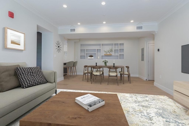 living room with ornamental molding, electric panel, and light hardwood / wood-style floors