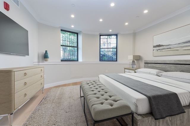 bedroom with light hardwood / wood-style floors and crown molding