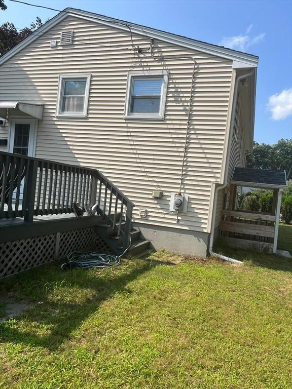 back of house with a lawn and a wooden deck