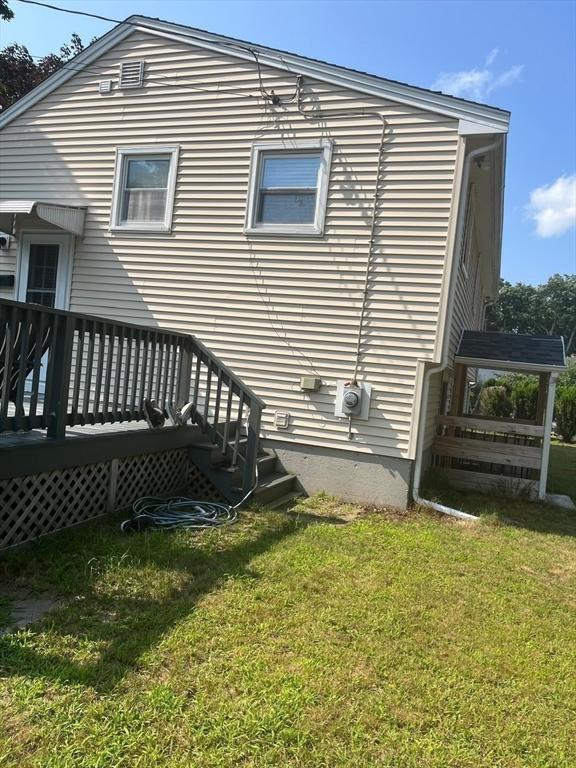 rear view of house with a lawn and a deck